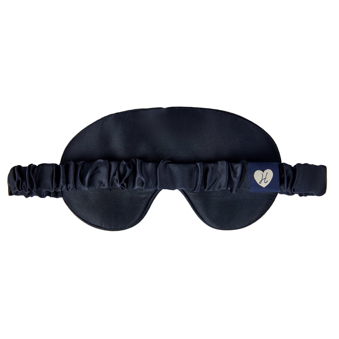 Woman wearing a black sleep mask with star and moon design on a dark navy background