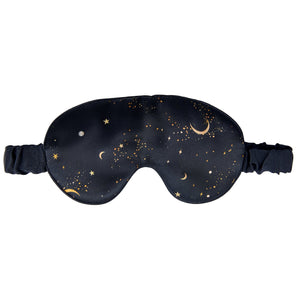 Woman wearing a black sleep mask with star and moon design on a dark navy background