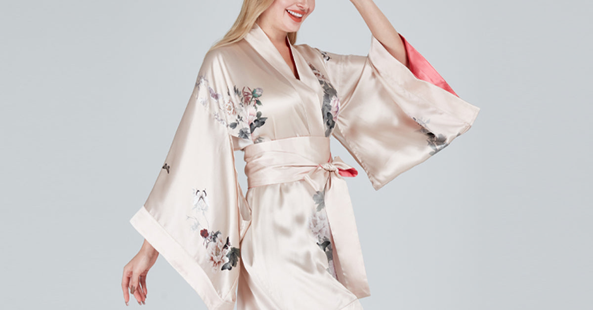 Woman wearing a beige satin kimono with floral patterns on a light gray background