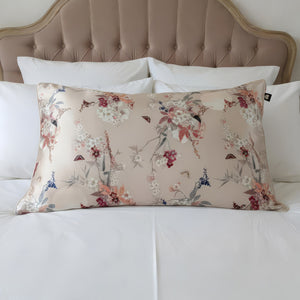 Floral-patterned pillow on a bed with a tufted headboard