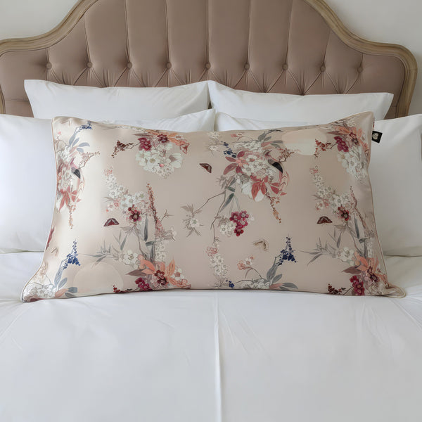 Floral-patterned pillow on a bed with a tufted headboard