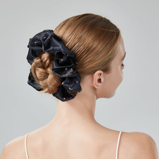 maxi jumbo scrunchie star and moon printed. A woman with a stylish hair updo against a plain background