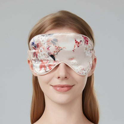 Woman wearing a floral sleep mask against a soft pink background