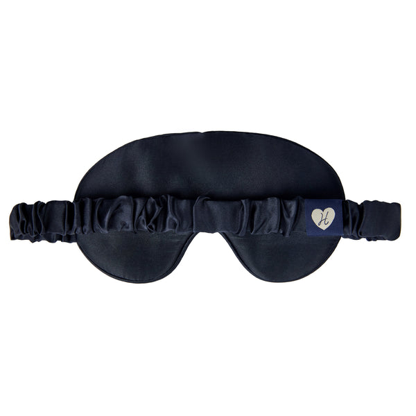Black satin sleep mask with a brand logo on a white background